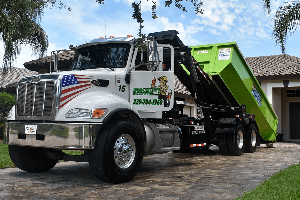 Truck delivering a dumpster to a home